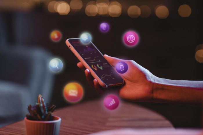 what does shadowbanning mean person holding phone with social media icons